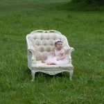 大きい白い椅子の座った赤ちゃん